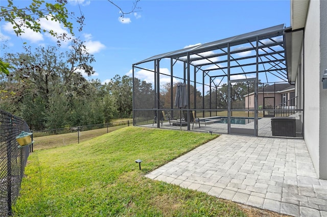 view of yard featuring a fenced in pool, glass enclosure, and a patio