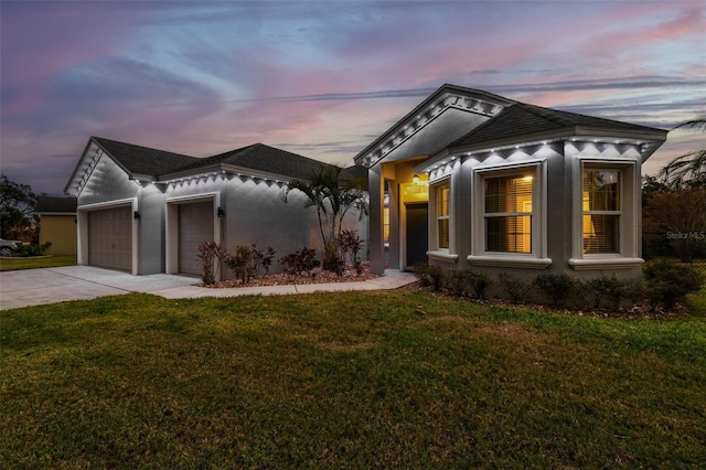 view of front of property with a yard and a garage