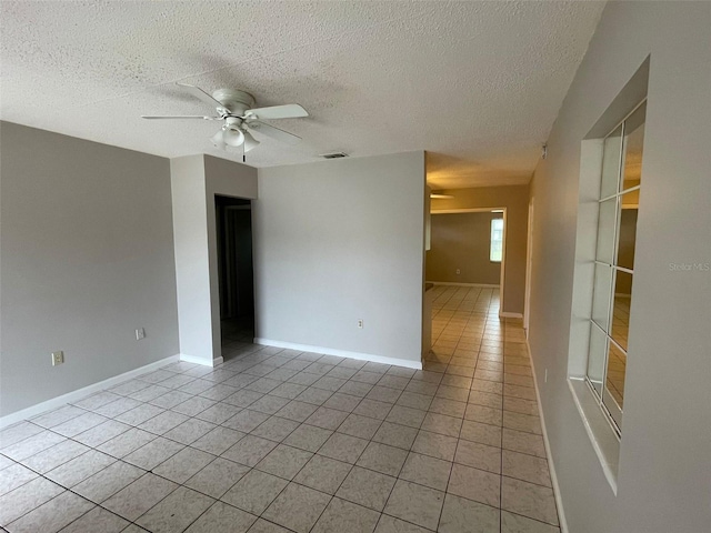 tiled spare room featuring ceiling fan and a textured ceiling