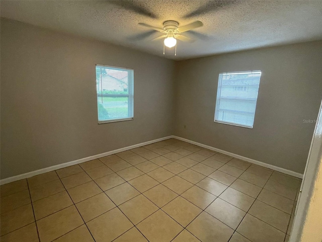 tiled spare room featuring ceiling fan