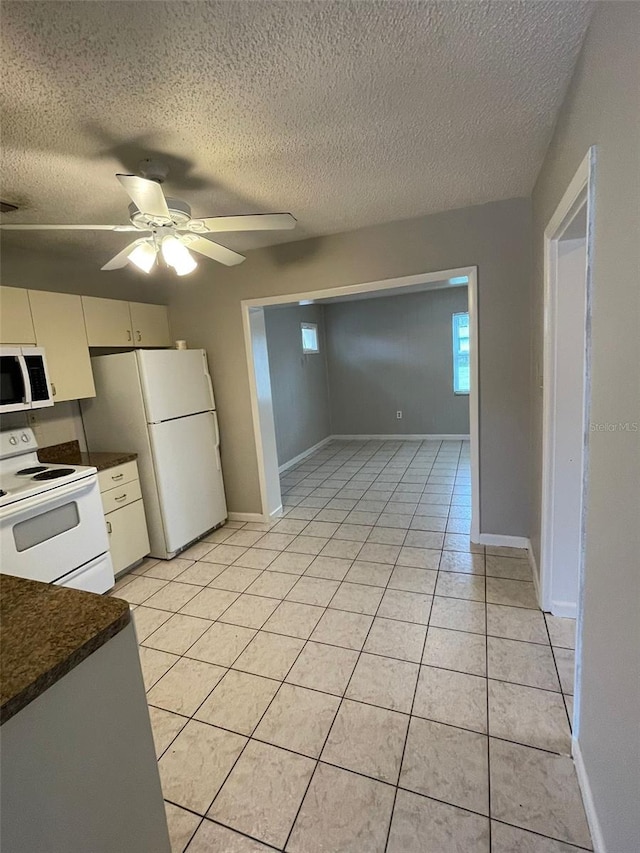 kitchen featuring light tile patterned floors, white appliances, a textured ceiling, and ceiling fan