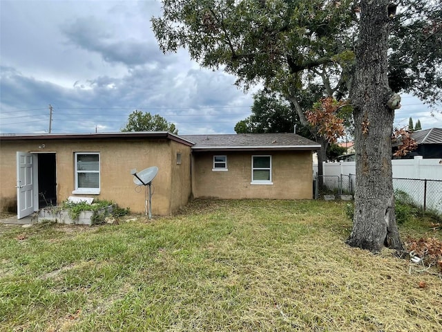 rear view of house featuring a yard