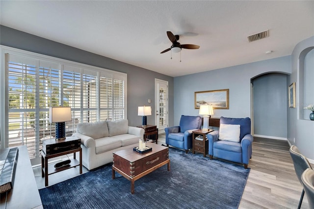 living room featuring hardwood / wood-style flooring, a textured ceiling, and ceiling fan