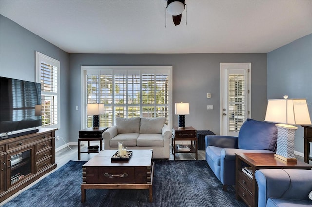 living room featuring ceiling fan, plenty of natural light, and dark hardwood / wood-style flooring