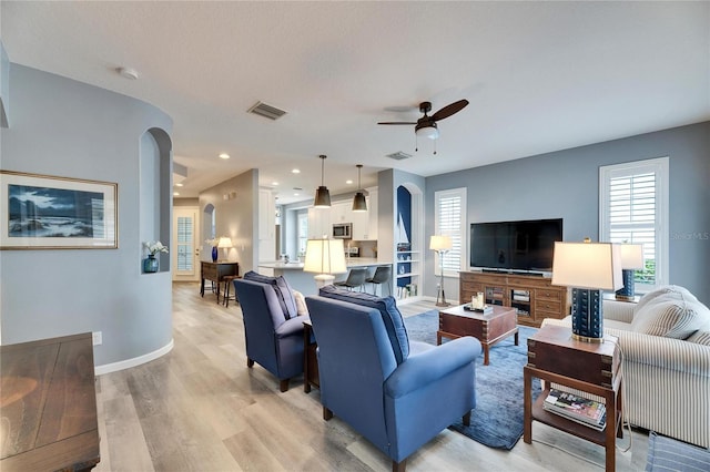 living room featuring ceiling fan and light hardwood / wood-style flooring