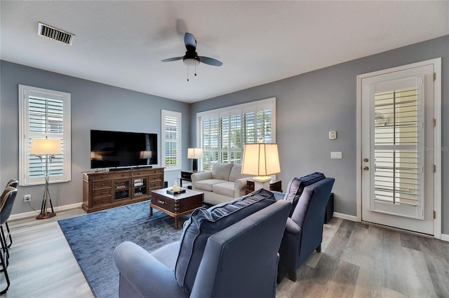 living room with ceiling fan, wood-type flooring, and a wealth of natural light