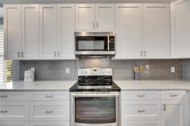 kitchen featuring appliances with stainless steel finishes, decorative backsplash, and white cabinets