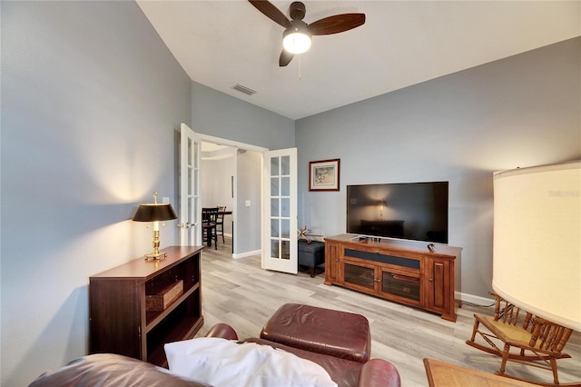 living room with light wood-type flooring, ceiling fan, and french doors