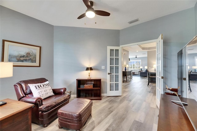 living room with ceiling fan, french doors, and light wood-type flooring