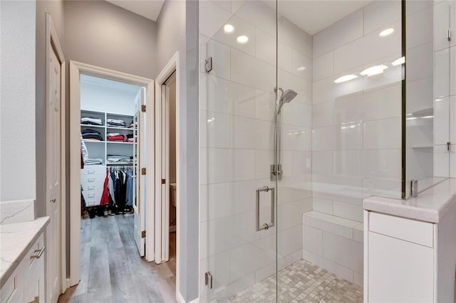 bathroom featuring wood-type flooring, an enclosed shower, and vanity