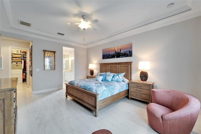 bedroom with a spacious closet, ceiling fan, ensuite bath, a closet, and ornamental molding