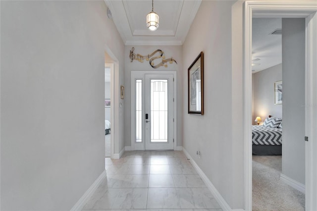 foyer entrance with light carpet and ornamental molding