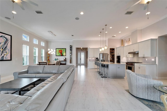 living room with ceiling fan, sink, and ornamental molding