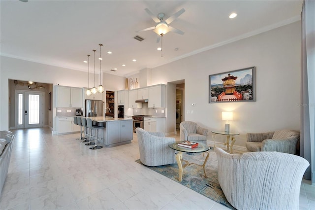 living room with ceiling fan, ornamental molding, washer / clothes dryer, and sink