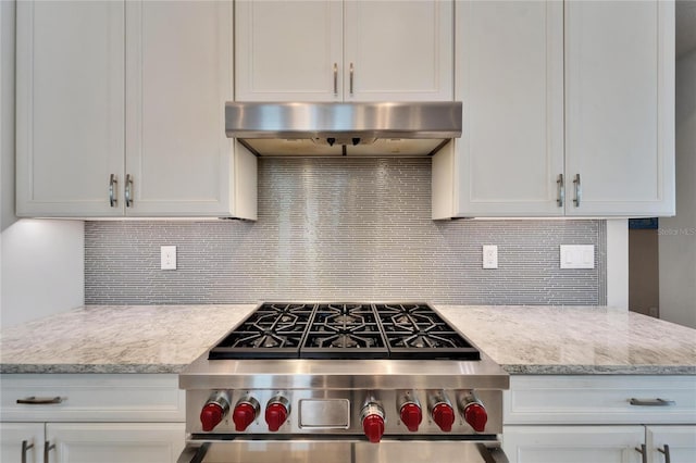 kitchen with tasteful backsplash, white cabinetry, and stainless steel stove