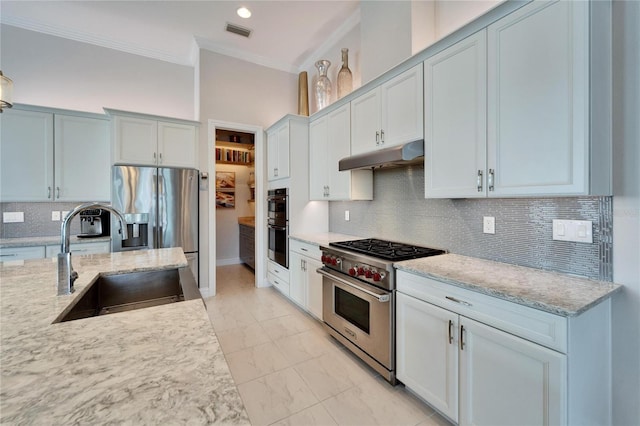 kitchen featuring light stone countertops, stainless steel appliances, sink, backsplash, and crown molding