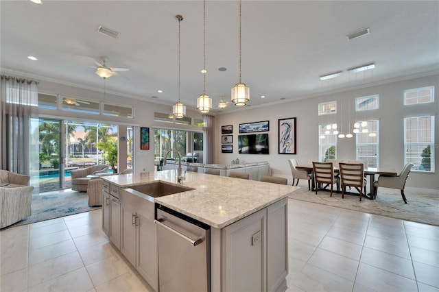 kitchen with a center island with sink, ceiling fan, stainless steel dishwasher, light stone counters, and sink