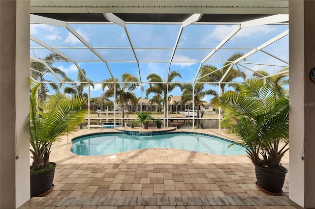 view of swimming pool featuring a lanai, a water view, and a patio area