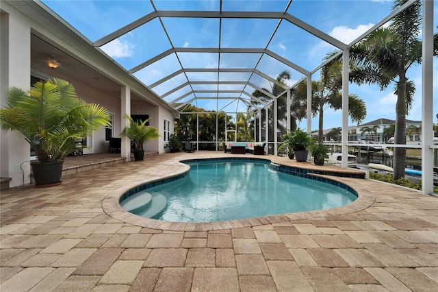 view of swimming pool featuring a lanai and a patio