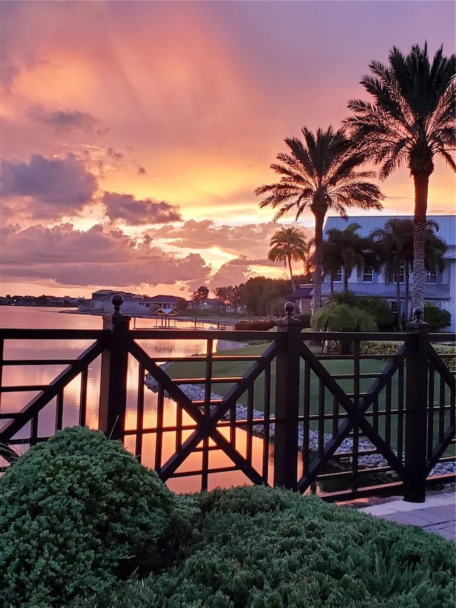 gate at dusk featuring a water view