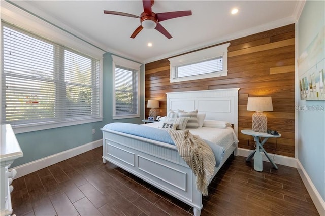 bedroom featuring ceiling fan, ornamental molding, and wooden walls