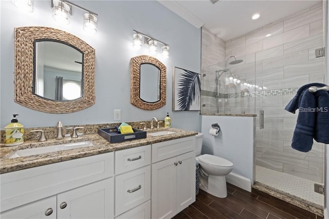 bathroom with toilet, crown molding, walk in shower, and vanity