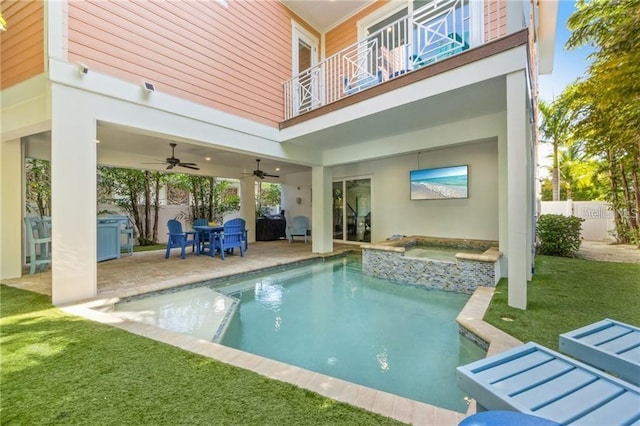 view of swimming pool with ceiling fan, an in ground hot tub, a yard, and a patio