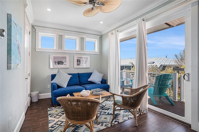 living area featuring crown molding, dark wood-type flooring, and ceiling fan