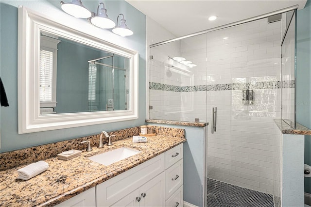 bathroom featuring vanity and a shower with shower door