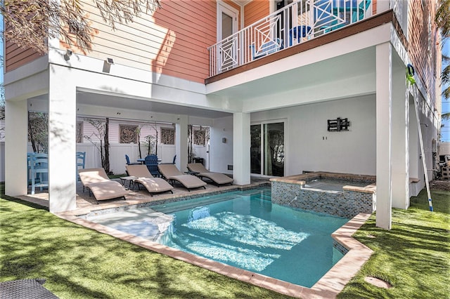 view of pool with an in ground hot tub, a patio area, and a lawn