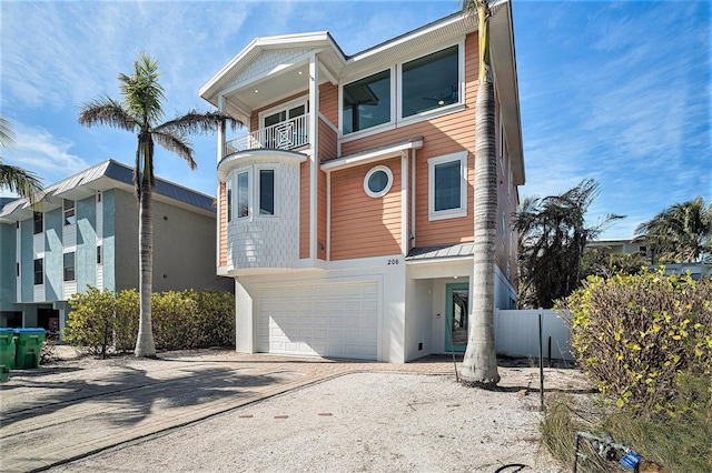 206 Church Ave, Bradenton Beach, FL 34217 - view of front facade featuring a balcony, driveway, fence, and an attached garage