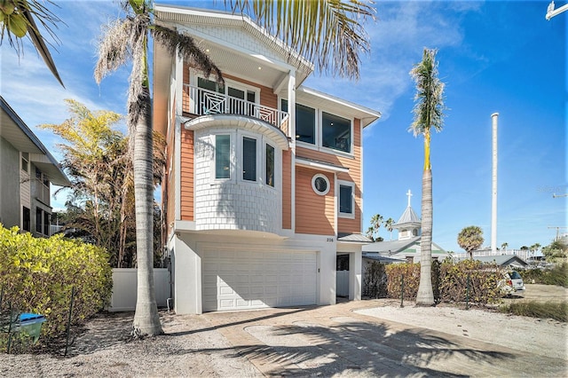 206 Church Ave, Bradenton Beach, FL 34217 - view of front of home featuring a balcony, driveway, a garage, and fence