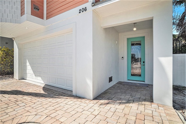 206 Church Ave, Bradenton Beach, FL 34217 - entrance to property with stucco siding, a garage, and visible vents