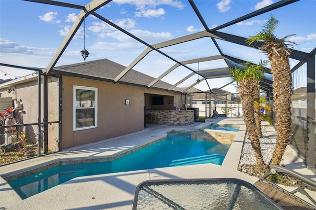 view of pool with a patio area, glass enclosure, and an in ground hot tub