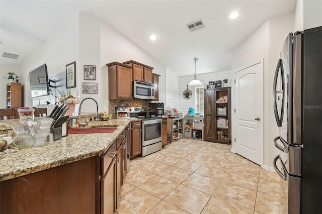 kitchen featuring sink, light tile patterned floors, tasteful backsplash, hanging light fixtures, and appliances with stainless steel finishes