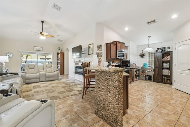 tiled living room featuring vaulted ceiling and ceiling fan