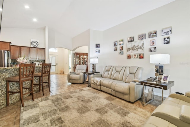 living room featuring high vaulted ceiling and light tile patterned floors