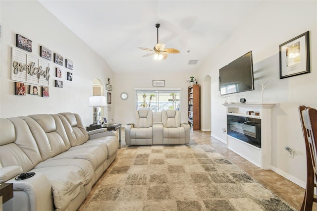 living room featuring ceiling fan, light tile patterned flooring, and lofted ceiling