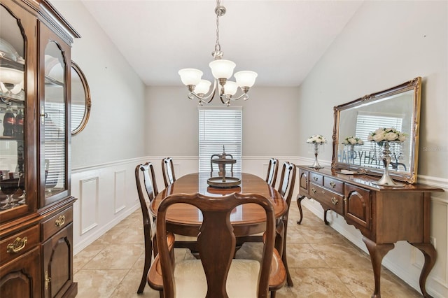 tiled dining area featuring vaulted ceiling and a chandelier