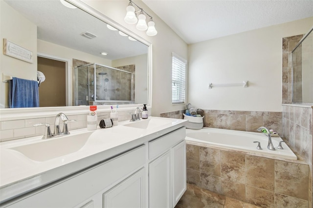 bathroom with vanity and shower with separate bathtub