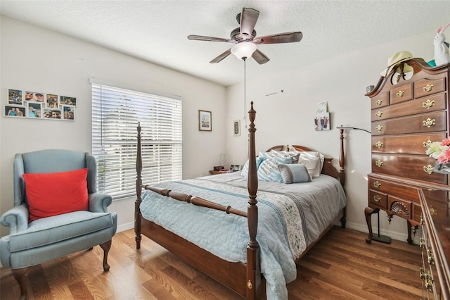 bedroom featuring dark hardwood / wood-style flooring, multiple windows, a textured ceiling, and ceiling fan