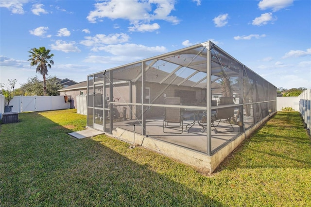 back of house with a lanai, a patio, and a yard