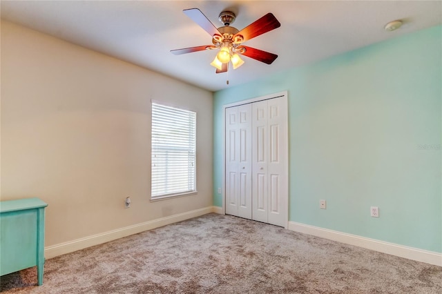 unfurnished bedroom featuring light carpet, a closet, and ceiling fan