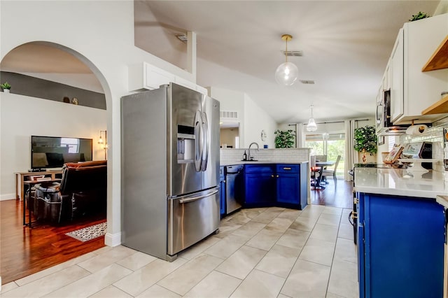 kitchen with appliances with stainless steel finishes, pendant lighting, blue cabinets, sink, and white cabinets