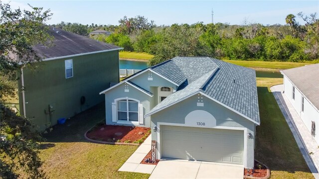 view of front of home featuring a garage, a water view, and a front lawn