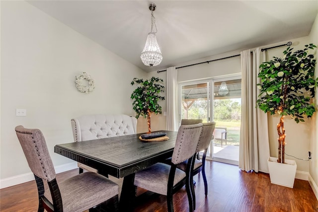 dining room with vaulted ceiling, dark wood-type flooring, and a notable chandelier