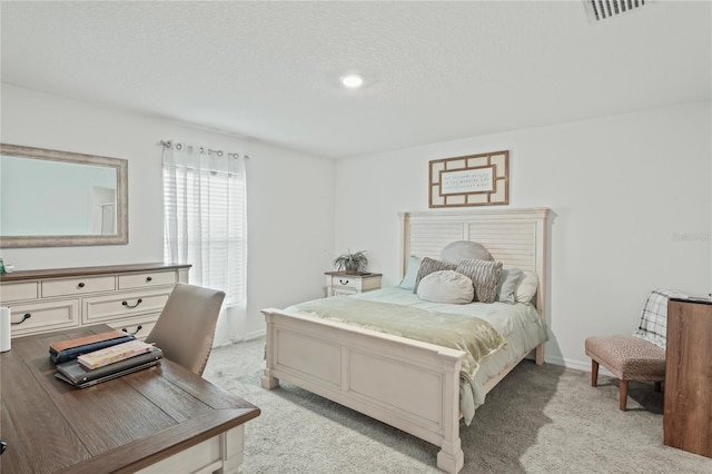 bedroom featuring light carpet and a textured ceiling