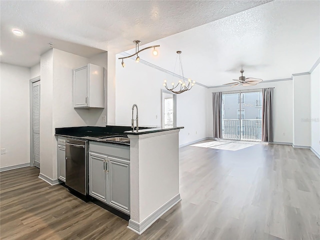 kitchen with hardwood / wood-style flooring, a textured ceiling, dishwasher, ceiling fan with notable chandelier, and sink