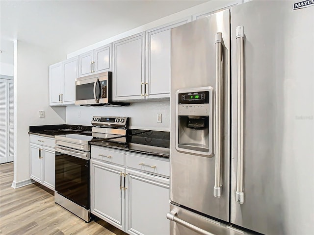 kitchen with white cabinetry, light hardwood / wood-style flooring, and appliances with stainless steel finishes