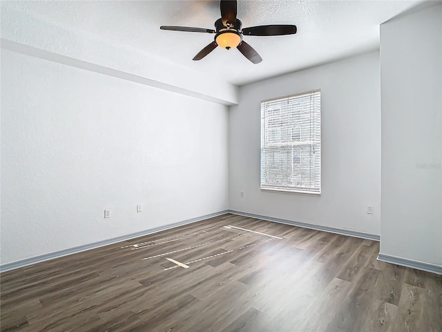 empty room featuring dark hardwood / wood-style flooring and ceiling fan